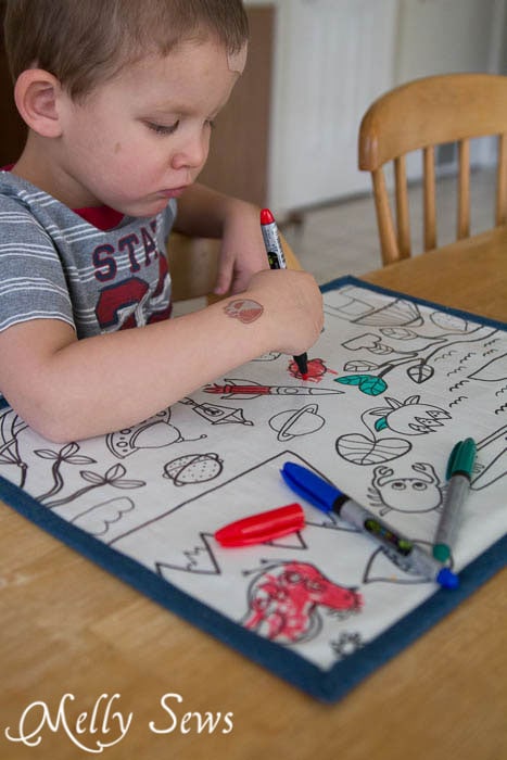Toddler using a busy mat at the dinner table