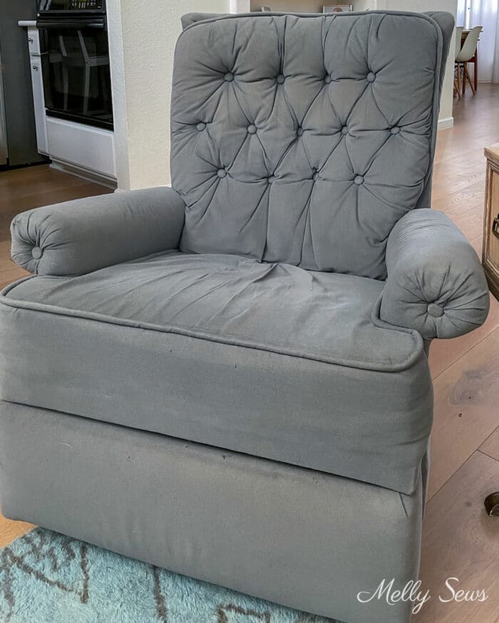 Recliner with discoloration on seatback and footrest as well as loose fabric on seat cushion