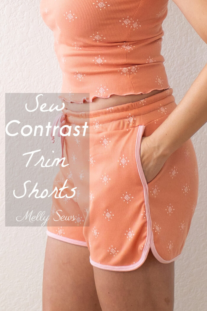Torso of a women wearing a matching top and retro gym shorts in terra cotta and blush with text Sew Contrast Trim Shorts