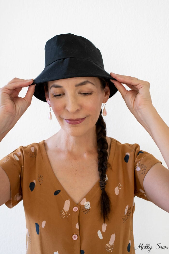 Brunette woman wearing a black twill bucket hat shew sewed