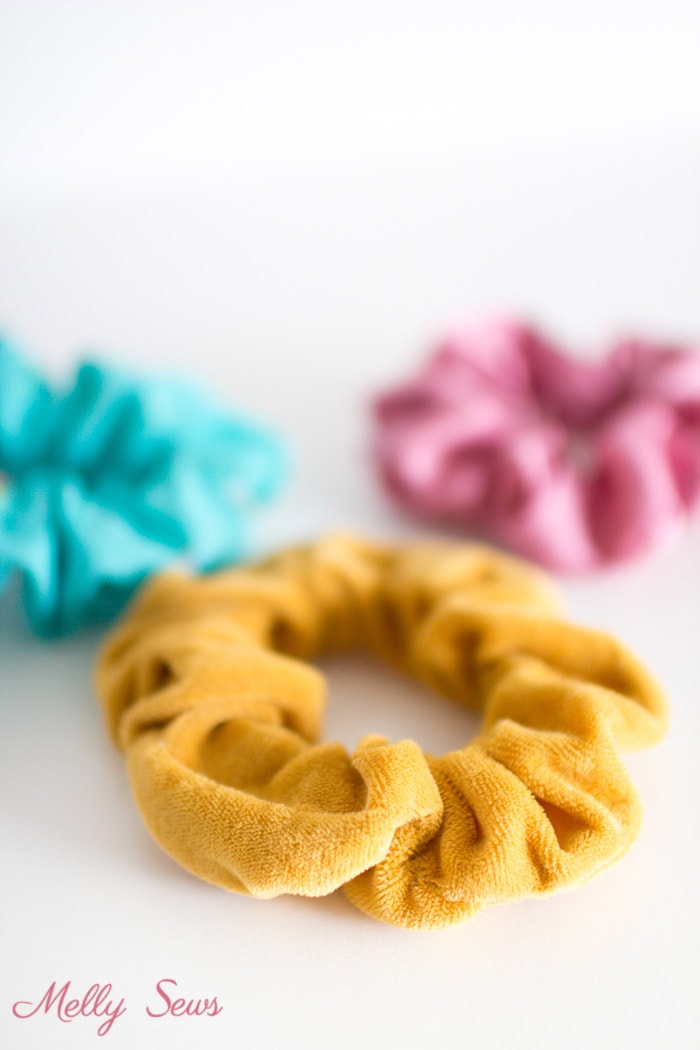 Handmade Scrunchie in yellow velvet with blue and pink scrunchies in the background