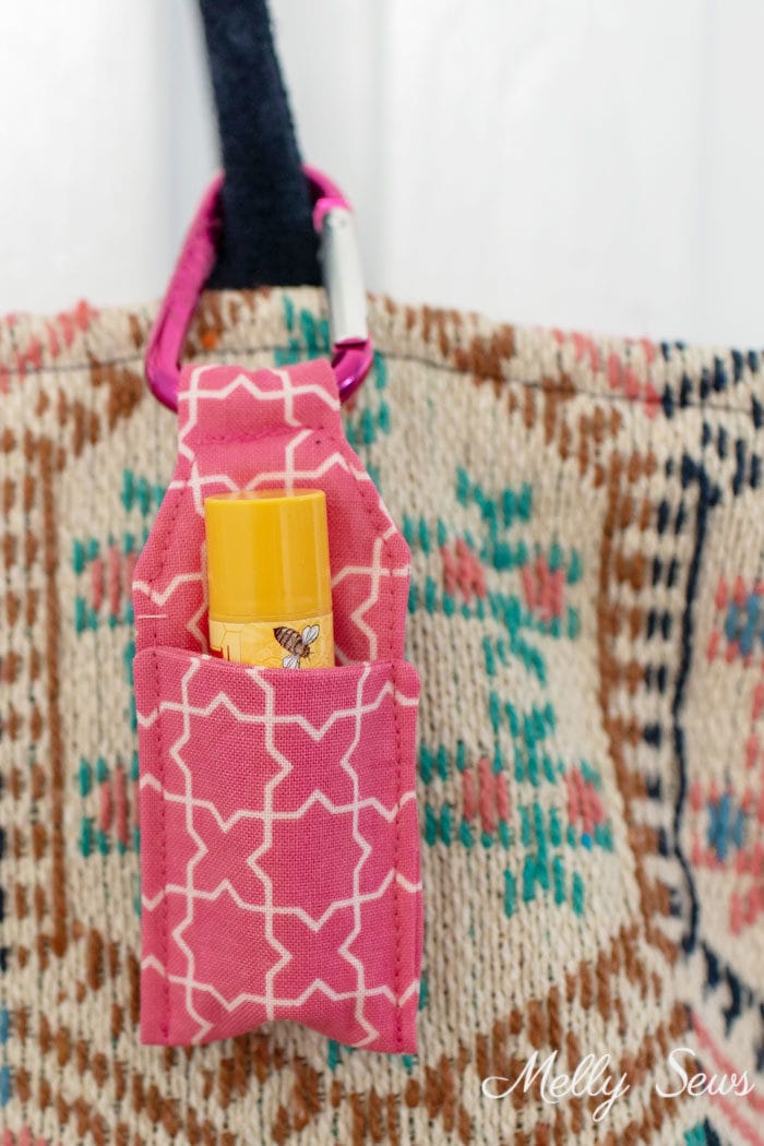 DIY Keychain chapstick holder sewn from tutorial clipped to bag handle 