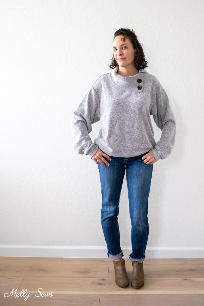 Woman in casual outfit of jeans, boots and a sweater with a button collar
