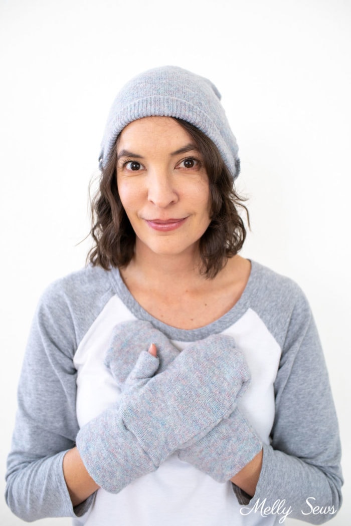 Woman wearing a DIY gray beanie and mittens sewn from a sweater