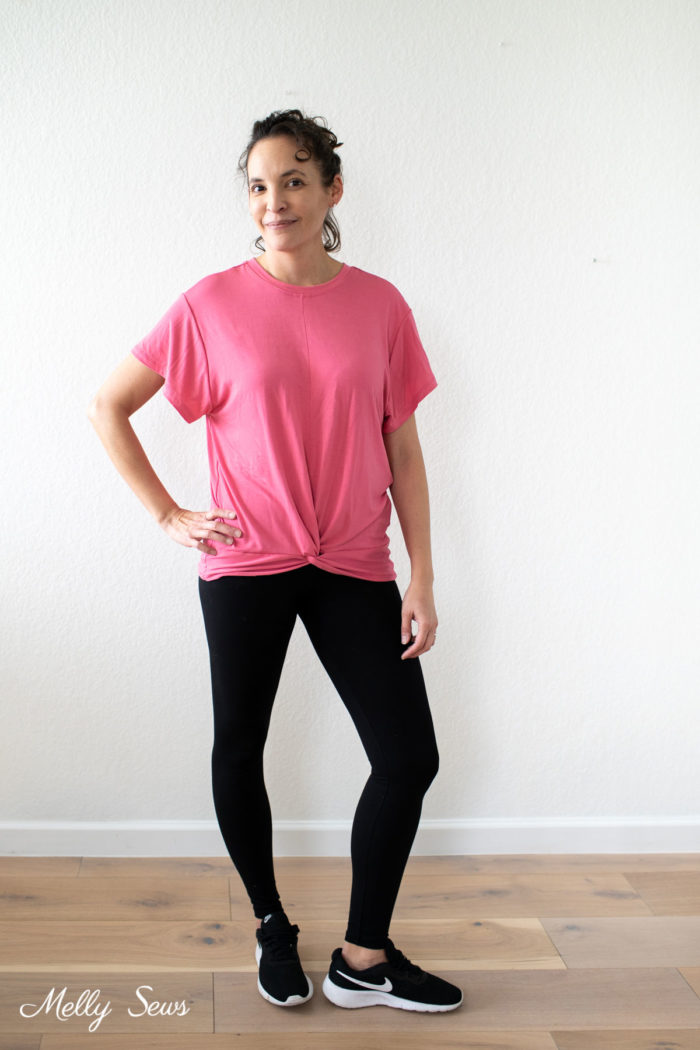 Woman wearing a coral shirt with black leggings casual workout outfit