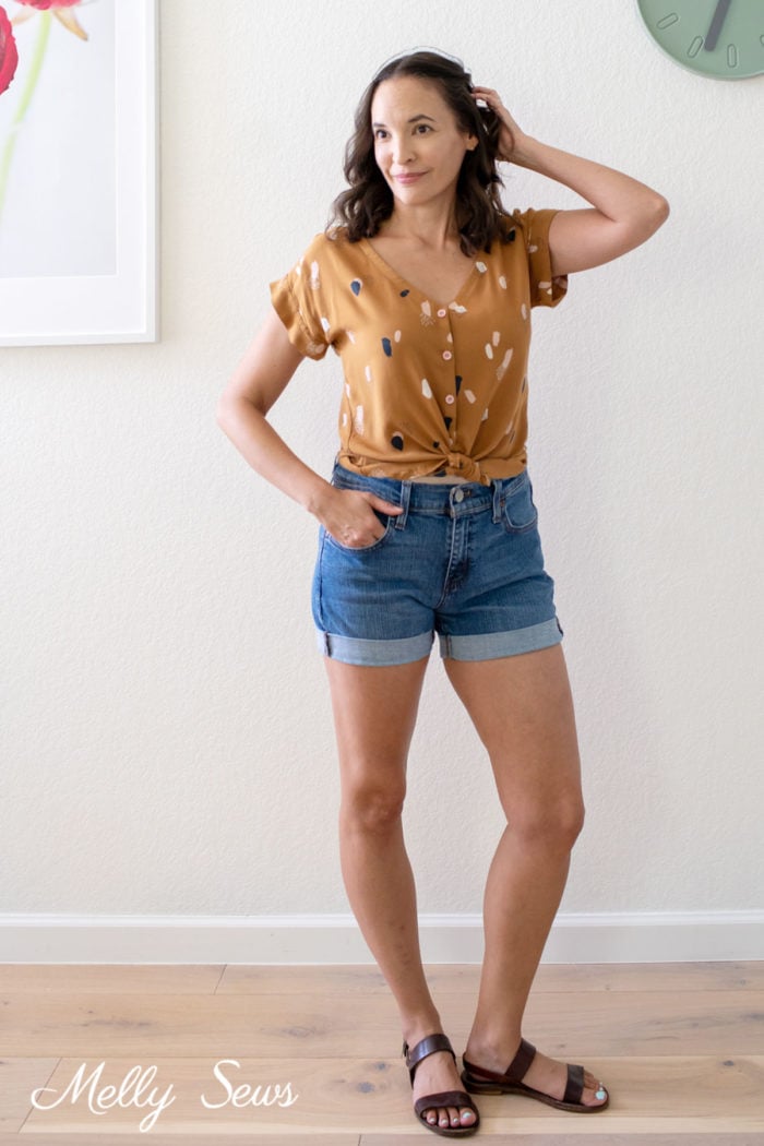 Woman in a button up shirt and denim shorts casual summer outfit