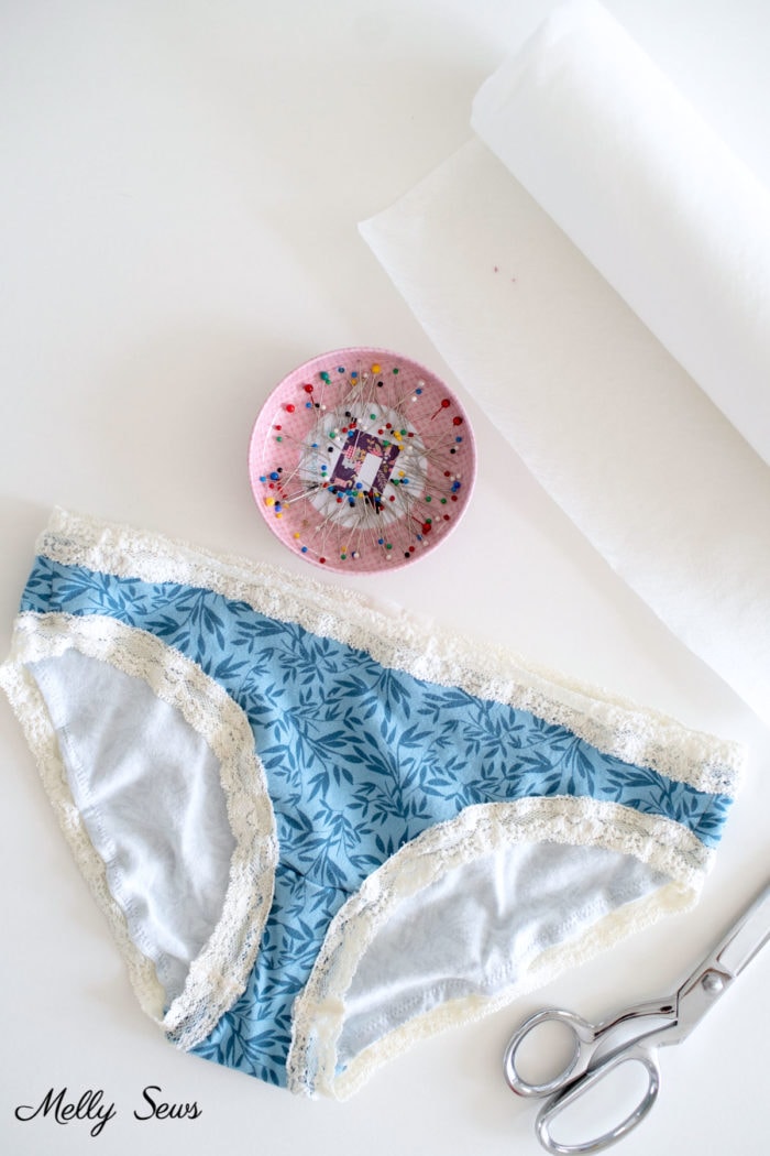Water soluble stabilizer, home sewn blue underwear, a pink pin dish and scissors