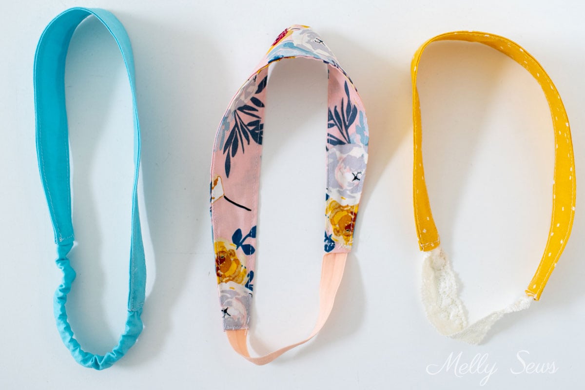 Three handmade headbands in aqua, a pink floral print, and yellow with lace elastic