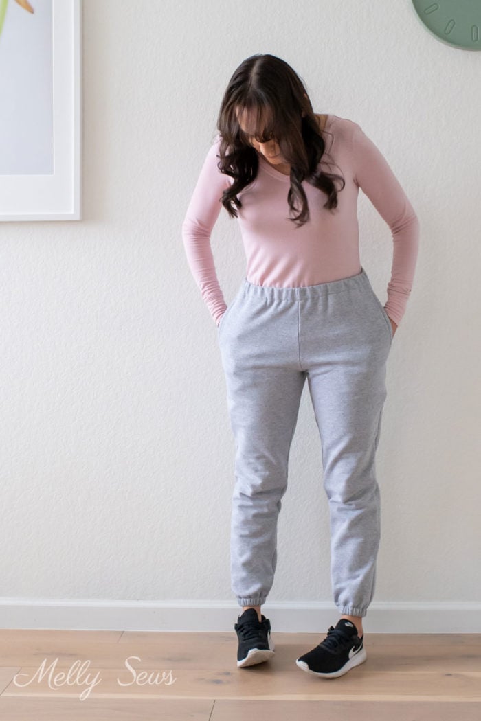 Woman with hands in pockets of gray sweatpants