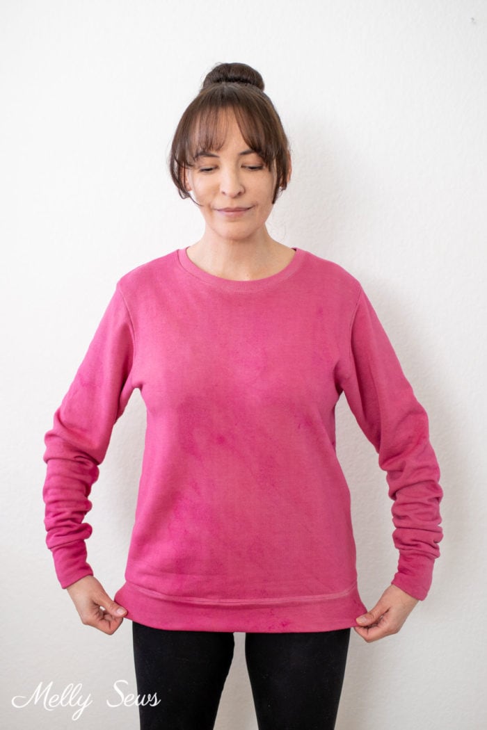 Brown haired woman wearing a pink sweatshirt