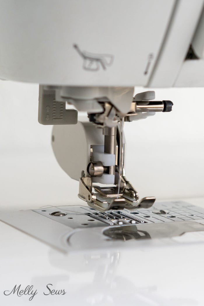 Close up of a walking foot on a sewing machine