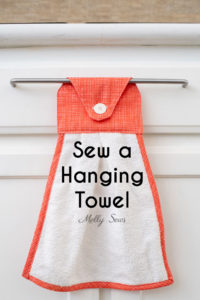 Kitchen towel sewing pattern with a hanging tab hanging on a drawer