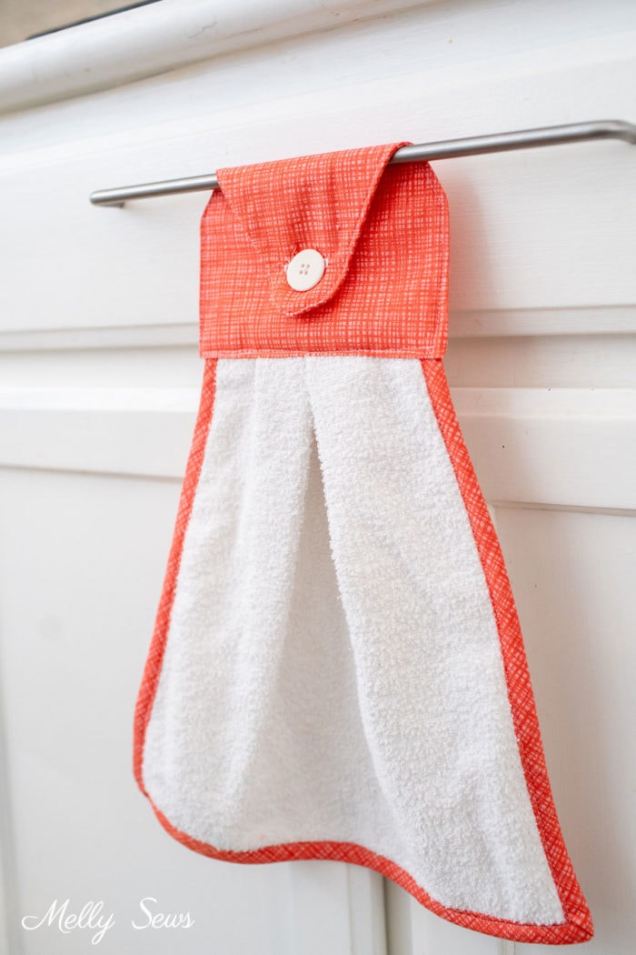 Dishtowel with button tab hanging on a drawer handle
