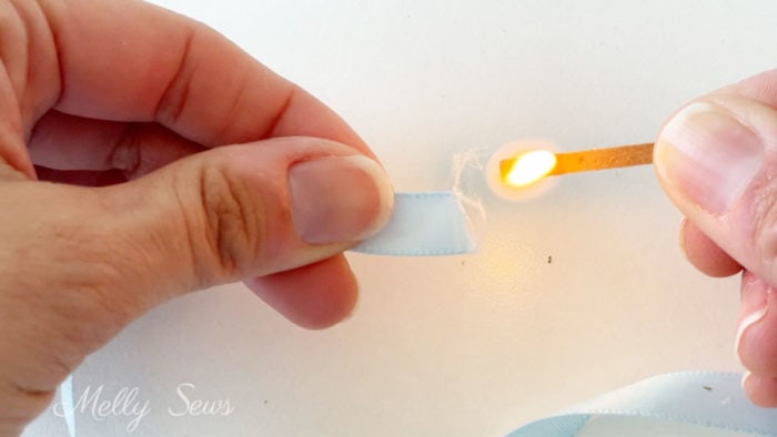 Use a match to melt and seal the cut end of synthetic (polyester) ribbon 