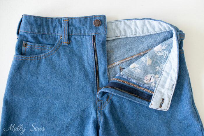 Denim DIY jean shorts on table showing inside of shorts