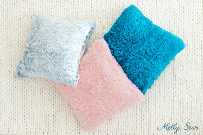 Faux fur pillows on sewn DIY style tossed on a rug