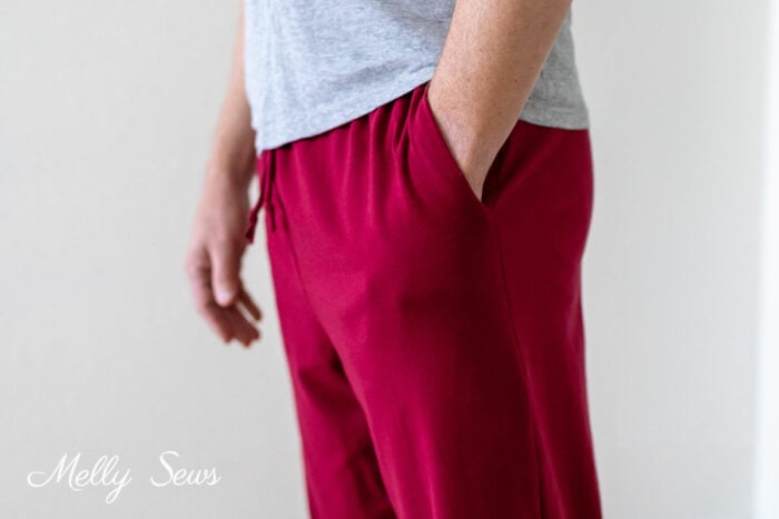 Close up of mans waist with his hand in the pocket of his pajama pants