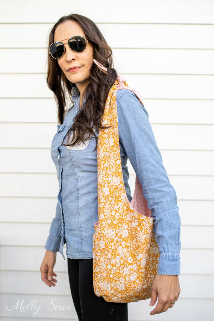 Brunette woman in sunglasses carrying a shoulder bag she sewed
