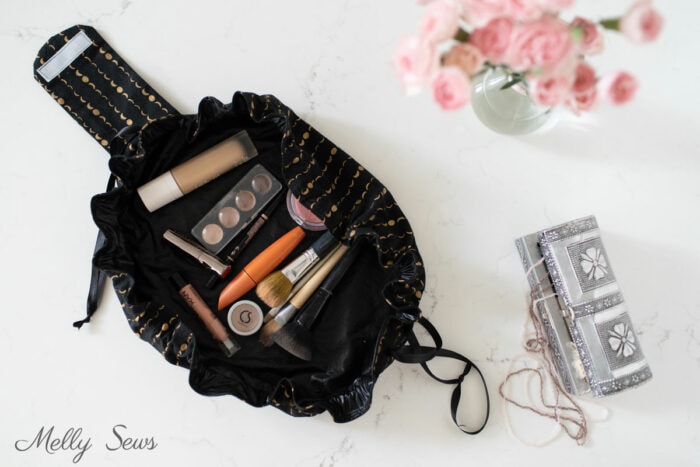 Black drawstring makeup bag on a white counter