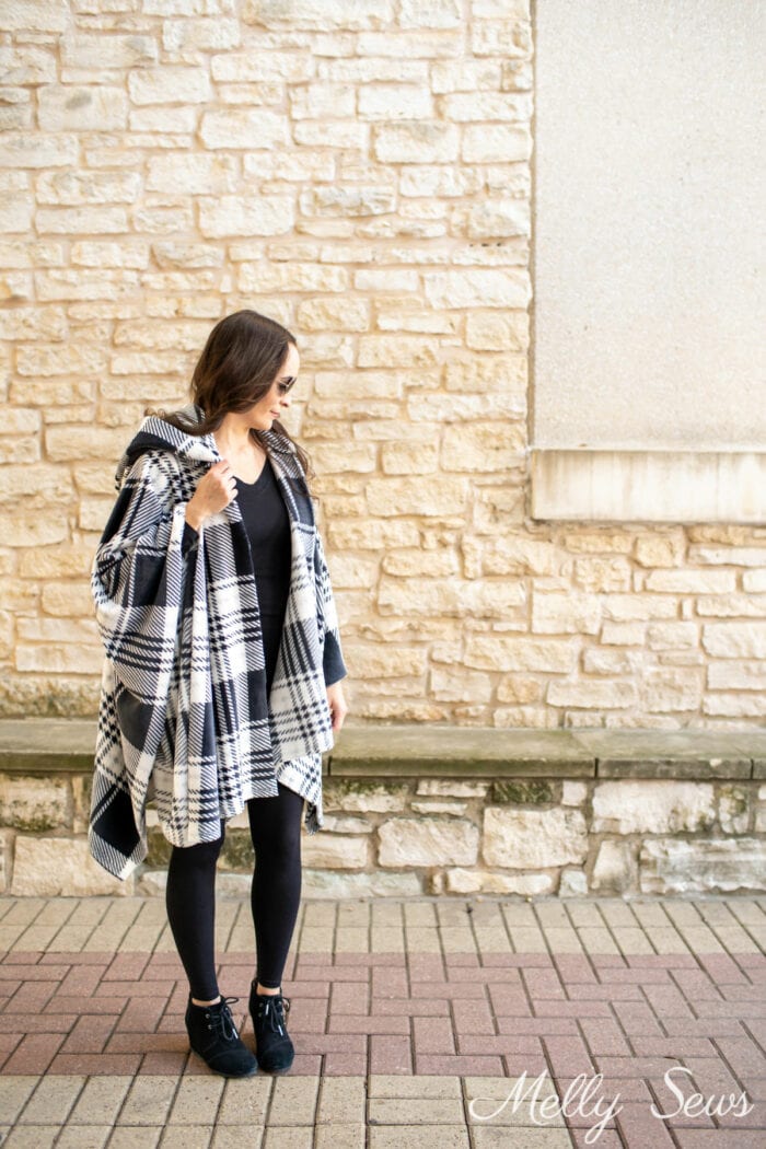 Woman wearing a plaid hooded blanket poncho