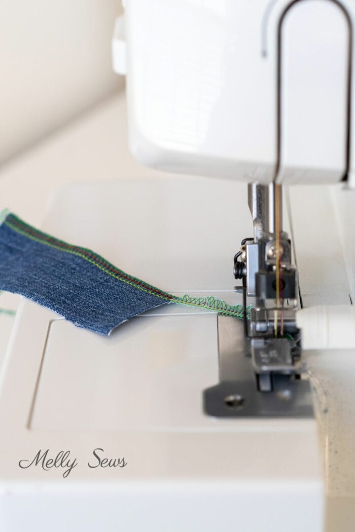 How to end a serger seam - blue fabric chained off behind the serger presser foot