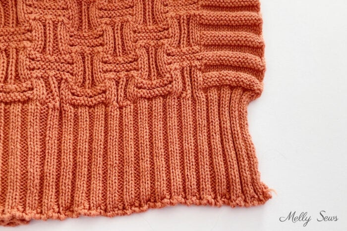 Close up image of rib knit and faux rib knit at the edge of a blanket