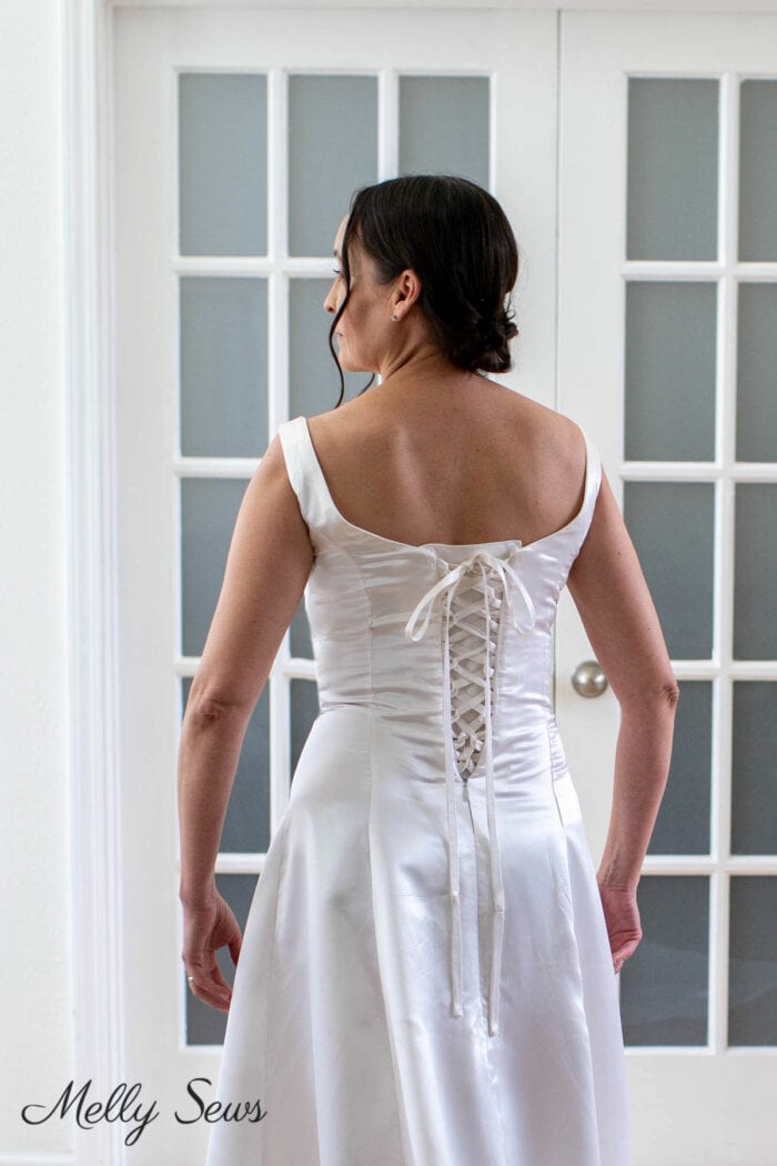 Woman wearing a wedding dress with a corset back replacing the zipper