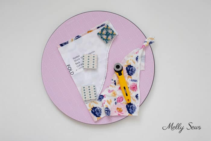 Partially cut panties pattern piece on a pink rotating cutting mat