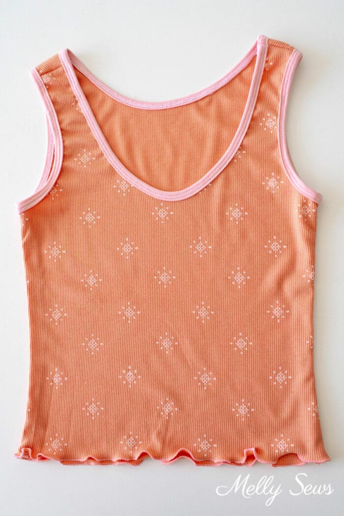 Rust colored tank top with pink print and pink bound neckline and armholes