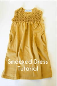 Gold fabric dress with beaded smocking detail laying on a white background