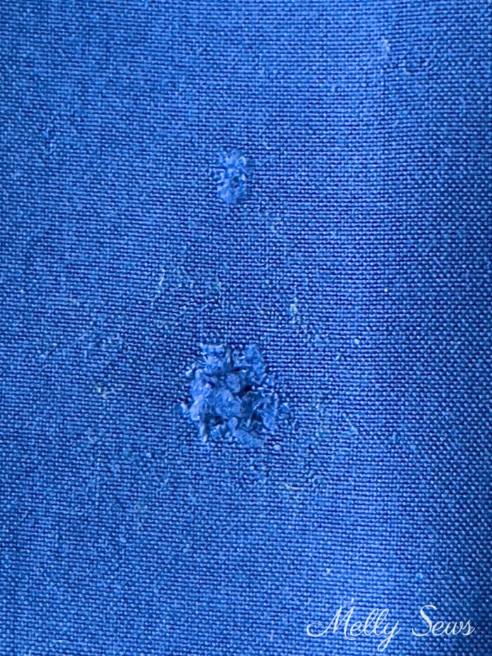 Blue fabric with two small holes in it