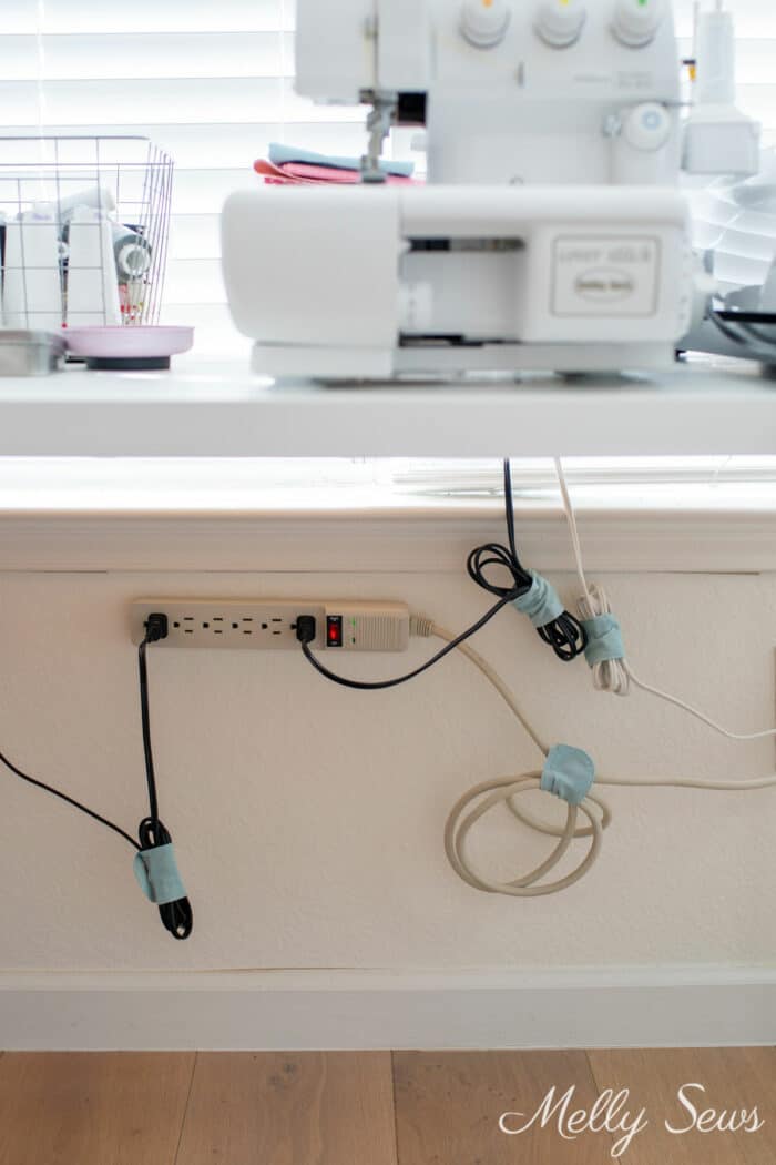 Cords under a sewing table wrapped with cord keepers