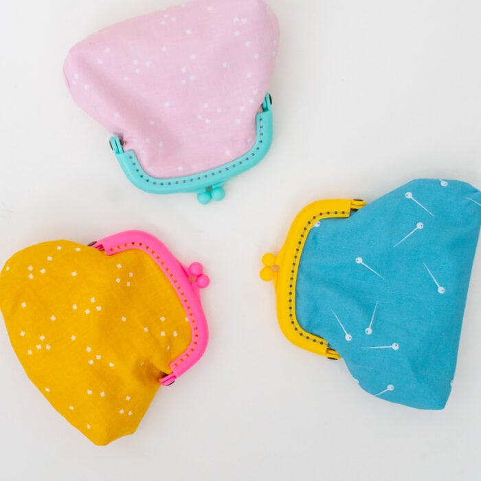 Three different coin pouches sewn in pink, gold and aqua