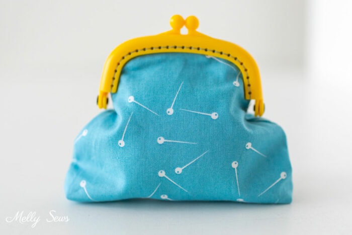 Blue teal pouch sewn with a yellow kiss clasp frame