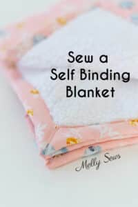 Sew a Self Binding Blanket text on image of a Faux sherpa fleece blanket with pink floral quilting cotton edges and backing