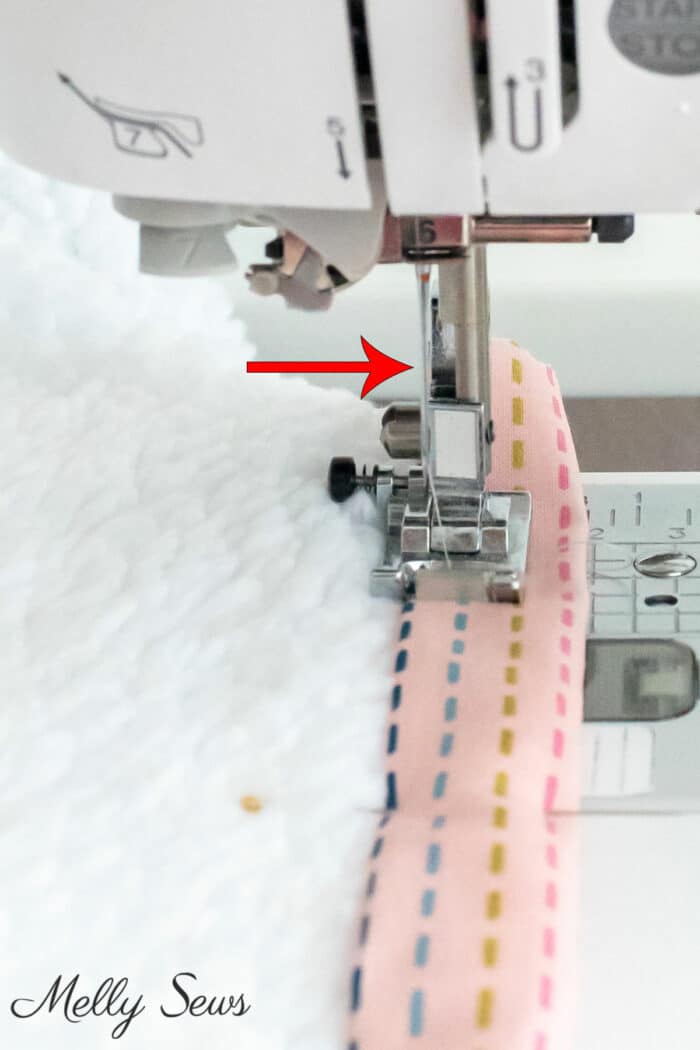 Close up of sewing machine sewing cotton binding to a fuzzy fleece blanket