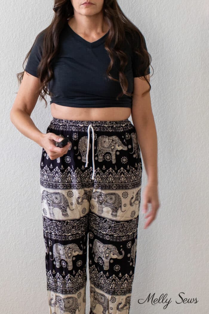Woman wearing black t-shirt and printed pants with a waistband that is too tight