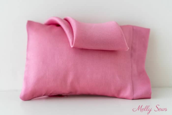 DIY pink satin pillowcase on a pillow with silk charmeuse fabric draped over it