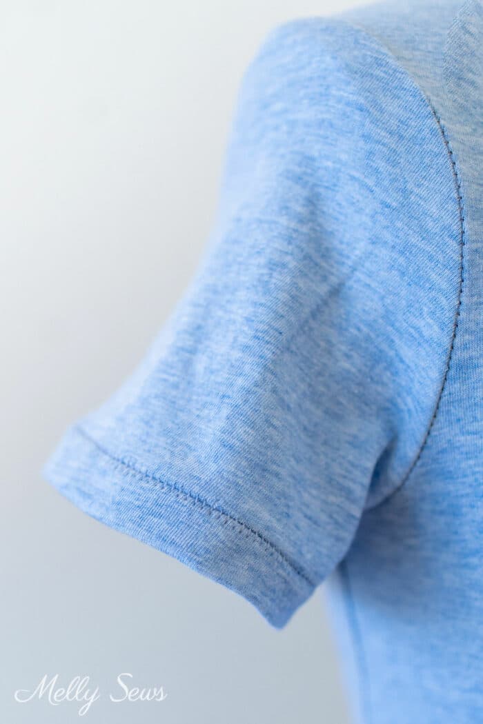Close of up sleeve on a blue t-shirt with a flat lock hem sewn on a serger