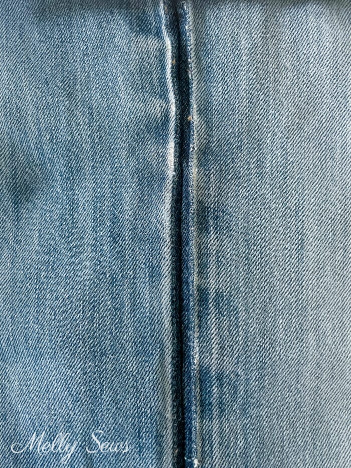 Seam on denim showing darker dye where the seam was let out
