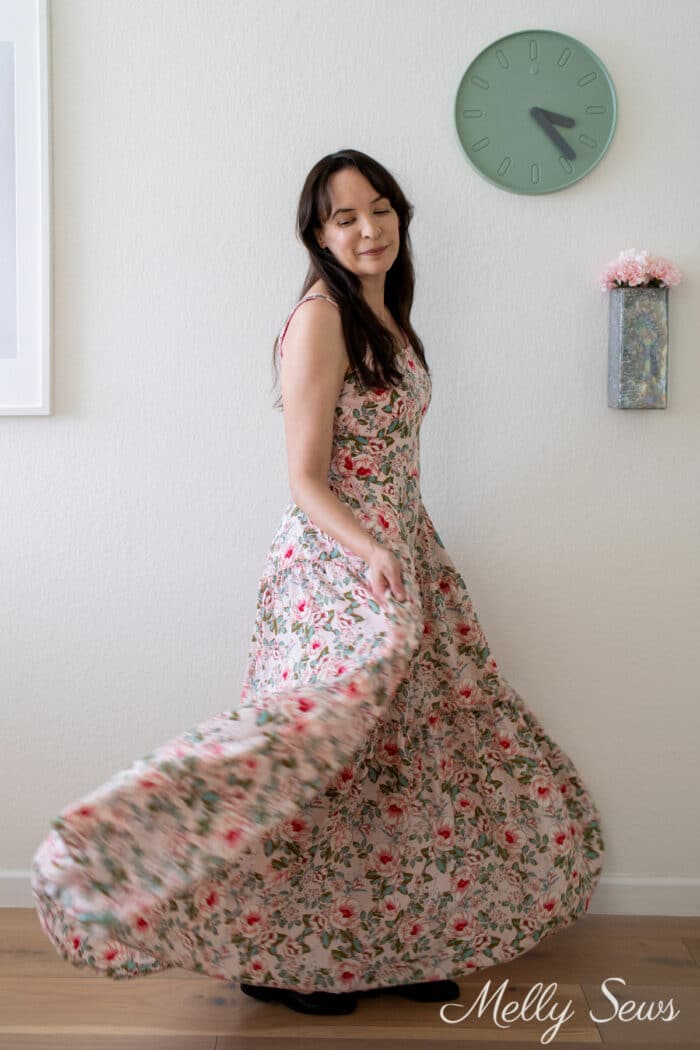 woman holding skirt and moving in a floral maxi dress