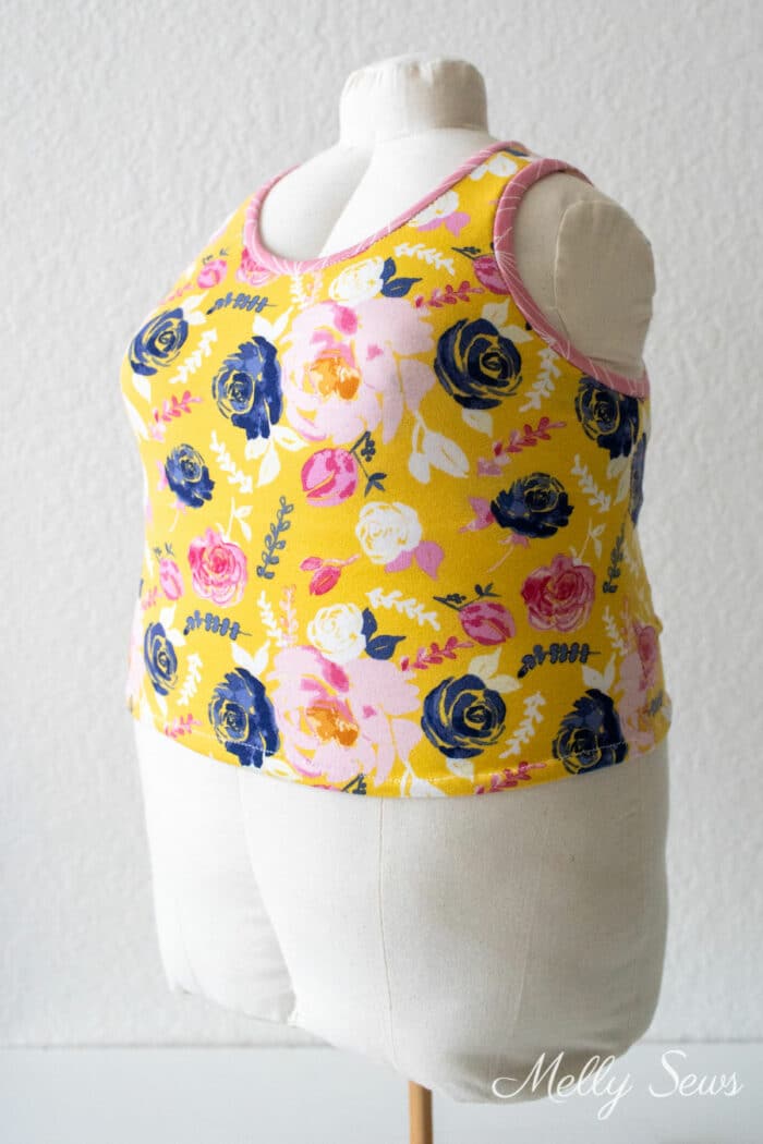 Floral print tank top with pink arm and neckbands on a dress form